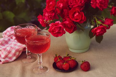 Yaz yemekleri hala hayat. Bir bardak kırmızı köpüklü çilek, çilek ve çikolata. Terasta tablo ayarları.