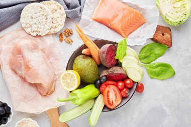 Ketogenik, Paleo, FODMAP, diyet konsepti. Meyveler, sebzeler, tavuk eti, ahşap kesim tahtasındaki yeşiller.