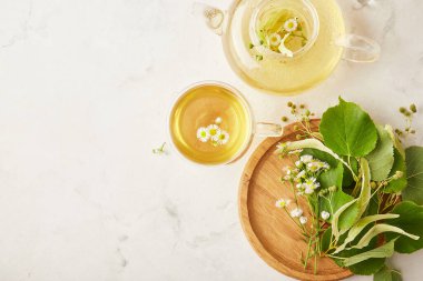 Sağlıklı organik bitkisel ıhlamur suyu ve papatya çayı. Doğal sıcak içecek, rahat bir masa. Boşluğu kopyala.