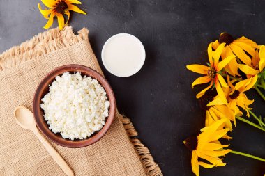 Doğal süzme peynir, ekşi süt peyniri. Diyet, Ukrayna yemeği. Sütlü ürün. Kırsal, çiçeklerle süslenmiş yemekler..
