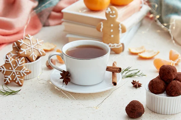 Aesthetic holidays food with coffee, tangerines, homemade gingerbread cookies, truffles and books. Aesthetic Christmas good mood background.