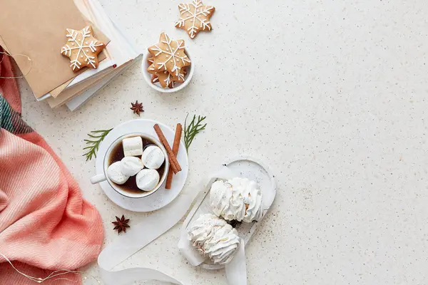 Aesthetic Christmas background with cup of cocoa, marshmallows, ginger snowflakes cookies, cinnamon sticks and books at cozy home flat lay. Copy space.
