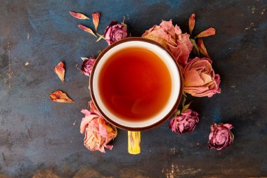 Kuru güllerin arasında sıcak sonbahar çayı fincanı..