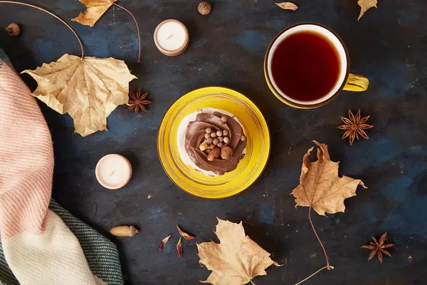Aesthetic Pavlova cake with Tea Cup. Autumn tea time vibes among leaves. Fall table setting.