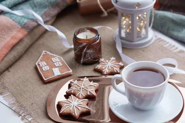 Atmospheric Christmas mood with homemade gingerbread cookies, cup of cocoa, flashlight, candles cozy background.
