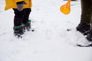 Baba oğul birlikte eğleniyor, aile zamanı. Şehirde karda eğlenen mutlu bir çocuk. Kış eğlencesi dışarıda. Yüksek kalite fotoğraf