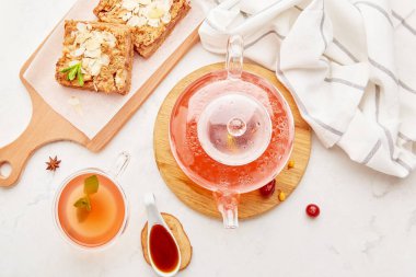 Lagom estetik sonbahar sofrası - ev yapımı tarçınlı elma tatlısı keki ve bir bardak kızılcık kızılcık köpek ağacı çayıyla birlikte cam çaydanlık