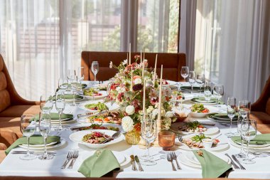 Mumlar ve çiçekler gölgelerin altında düzenlenmiş zarif oda masası. Provence estetiği düğün stili.