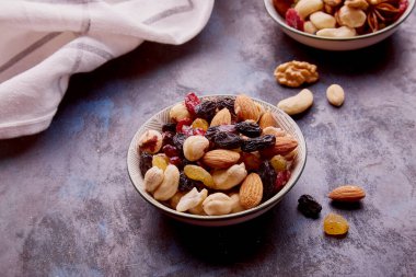 Karışık fındıklı çay tabakları. Sağlıklı tatlılar ve atıştırmalıklar. Ceviz, badem, fındık ve kaju. Kuru üzümler ve kızılcıklar kapanıyor