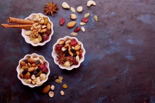 Aesthetic saucers with assorted nuts. Almonds, hazelnuts, walnuts and cashews. Raisins and cranberries. Healthy food and snacks. Copy space.