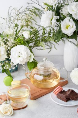 Estetik masa - çaydanlık, fincan, tatlılar, beyaz çiçekler - kendine zaman ayır, rahat ev konsepti