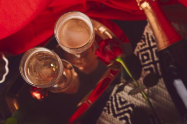 Geleneksel Sevgililer Günü masa takımı. Kırmızı güller, şampanya kadehleri, çikolata şekerlemeleri - Mevsimlik romantik akşam yemeği düzlüğü.