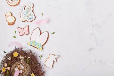 Beyaz zemin üzerine dekore edilmiş yuva ve Paskalya kurabiyeleri, düz yatağı kopyala. Paskalya bayrağı.