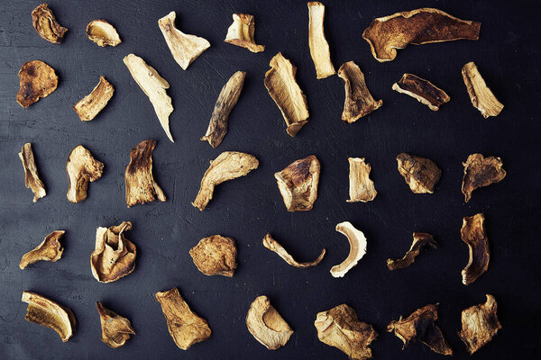 Сушеные грибы из свинины, повторяющийся узор, богатая антиоксидантами еда на деревенском фоне. Природные дикие продукты - низкий экологический след, устойчивый продукт вблизи