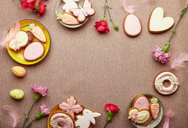 Bahar Paskalya pastel arka planı. Süslü Paskalya kurabiyeleri, tüylü pembe çiçekler ve yumurtalar.