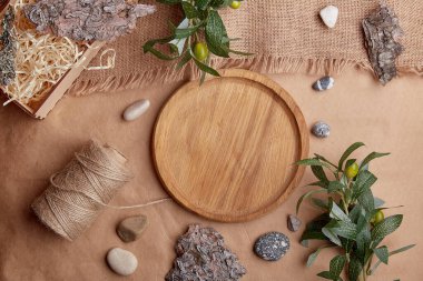 Sıfır atık tahta plaka, kahverengi doğal sürdürülebilir, çevre dostu yaşam tarzı. Doğal ağaç kabuğu, yeşil yapraklar, çakıl taşları..