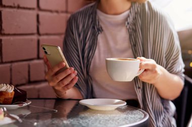 Kahve molasında meşgul gününün tadını çıkaran bir kadın. Şehir hayatı, şehir hayatı..