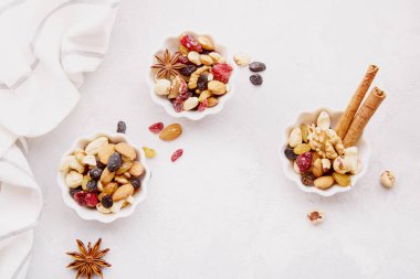Çeşit çeşit fındık dolu estetik tabaklar. Ceviz, badem, fındık ve kaju. Kuru üzüm ve kızılcık. Sağlıklı yiyecek ve atıştırmalıklar. Üst görünüm.