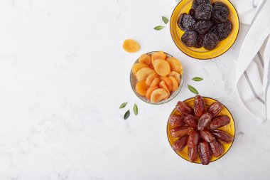Sağlıklı aperatifler, tatlılar üst görünüm - kuru erikler, kurutulmuş kayısılar, kopyalanmış alanla tarihler.