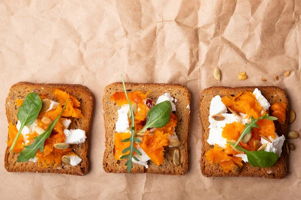 stock image Savory pumpkin bruschetta with feta cheese and a delicate leafy topping. Rustic comfort food.