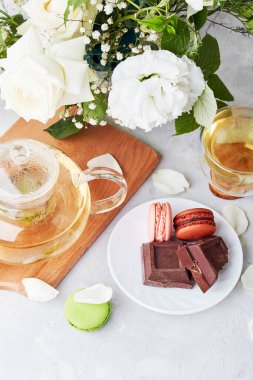 Estetik bir sabah. Yeşil çay, badem kurabiyesi, çikolata, beyaz buket - kendine zaman ayır, yavaş yaşam konsepti