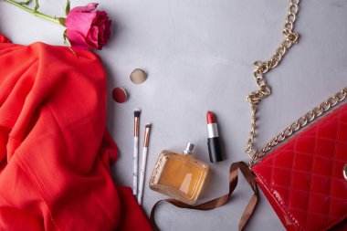 Kadınsı esanslar parfüm, ruj, makyaj fırçası ve taze çiçekler..
