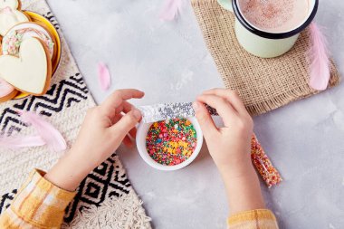 Süslü kurabiyelerle süslenmiş Paskalya sevinci. Tatlı kakao ve pastel kurabiyelerin arasında çocuk elleriyle serpiştirilmiş..