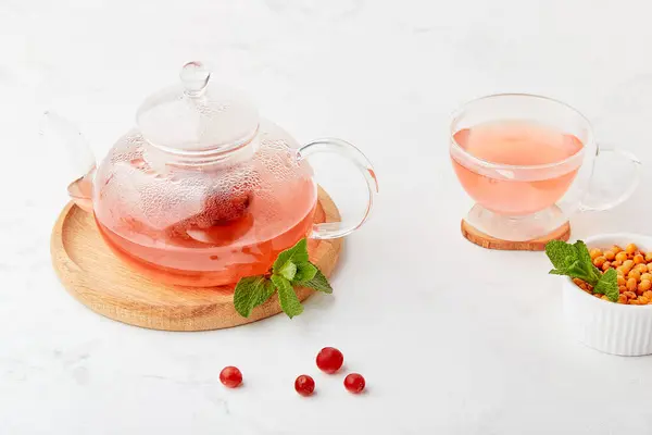 Aesthetic lagom home with warm cranberry, dogwood, sea buckthorn natural tea. Seasonal healthy drink.