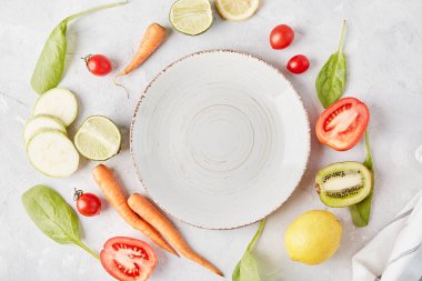 Estetik, vegan, organik, sağlıklı yiyecekler, bitkisel beslenme konsepti. Sebze ve meyvelerin arasındaki masada beyaz tabak. .