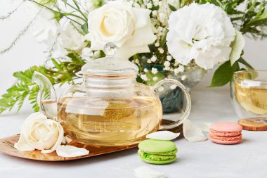 Estetik bir sabah. Yeşil çay, badem kurabiyesi tatlısı, beyaz buket yaşam tarzı. Kadınsı, kendine meditasyon zamanı, yavaş yaşam konsepti