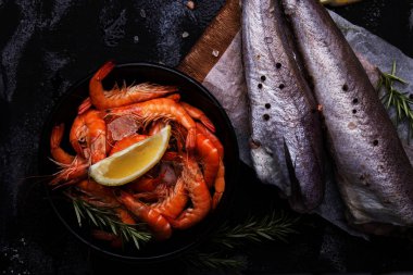 Restoran menüsü görselleri için çeşitli pişmemiş deniz ürünleri, karides ve limonlu hake balığı.