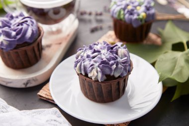 Estetik mor moda çiçek keklerini kapatıyoruz. Leylak çiçeklerinin arasında şekersiz mor tatlı.