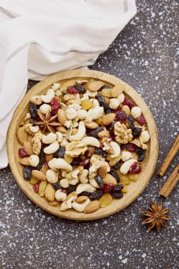 Estetik ahşap kase, çeşitli fındıklı üst manzara. Sağlıklı yiyecek ve atıştırmalıklar. Ceviz, badem, fındık ve kaju. Kuru üzüm ve kızılcık.