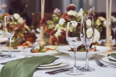 Arka plan ayarlayan estetik sonbahar masası, doğal ışık altında düzenlenmiş çiçekler ve mumlar. Konforlu tatil tablosu.