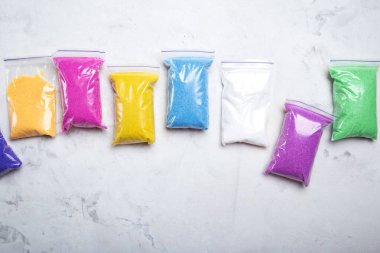 Renkli kum torbaları, sanatsal dekorasyon için çeşitli renklerde sergileniyor..