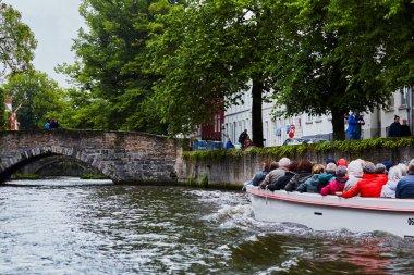 Bruges, Belçika - 31 Mayıs 2024 - Bahar Bruges, teknede turistler. Bruges Kanal Turu. Bahar doğası altında seyahat etmek