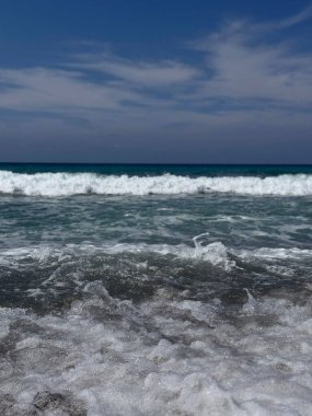 Güneşli bir deniz gününde dalgalar çarpar