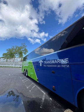 Ukrayna - 12 Mayıs - Markalı bir Flixbus, Transmarine şehirlerarası vagon, mavi ve yeşil dizaynlı, beyaz bulutlu, canlı mavi bir gökyüzünün altında, Avrupa 'da konforlu yol yolculuğunun sembolü.