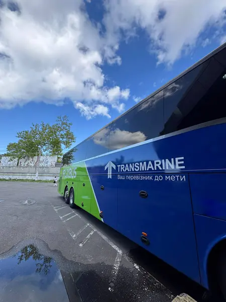Ukrayna - 12 Mayıs - Markalı bir Flixbus, Transmarine şehirlerarası vagon, mavi ve yeşil dizaynlı, beyaz bulutlu, canlı mavi bir gökyüzünün altında, Avrupa 'da konforlu yol yolculuğunun sembolü.