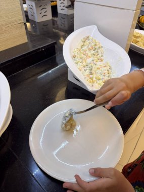 Childs, oteldeki açık büfeden yemek seçiyor. Çocuklar için gıda, bağımsızlık ve otel konukseverliği.