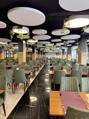 Her şeyi kapsayan bir restoranda şık bir yemek salonu. Hazırlanmış yer ayarlarıyla masalar, arka planda açık büfe alanı. Konukseverlik, tatil yemeği ve konfor kavramı.