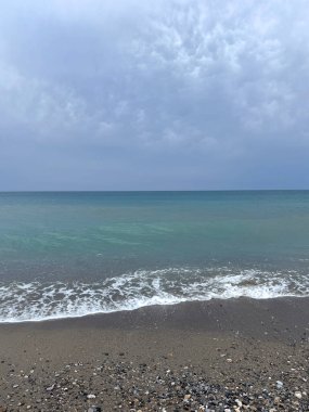 Sakin, berrak deniz, parlak mavi gökyüzünün altında. Yumuşak dalgalar ve dingin su, yolculuk, rahatlama, doğa ve refah projeleri için mükemmel huzurlu bir atmosfer yaratır..
