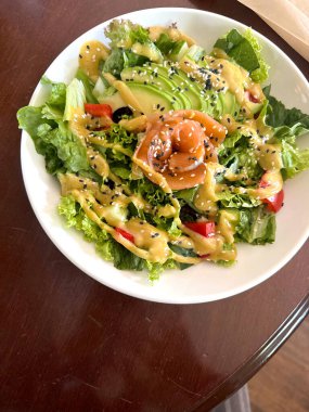 Taze somon ve beyaz kasede avokado salatası. Dengeli malzemeler, sağlıklı yemek, tepeden tırnağa görüş, temiz gıda konsepti.