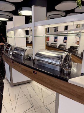 Çağdaş büfe, paslanmaz çelik tepsilerle kaplı otelin yemek odası. Tatil köyü yemek servisi ve konukseverlik endüstrisi kavramı.