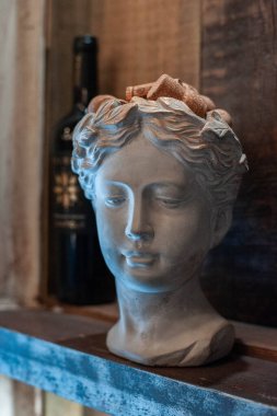 White plaster copy of an ancient head statue for artists on a white background. Plaster sculpture of a woman's face. Decor element for room design.