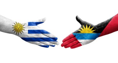 Antigua ve Barbuda ile Uruguay bayrakları arasındaki el sıkışma, izole şeffaf görüntü.