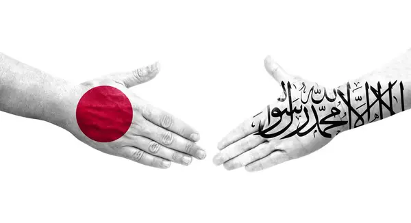 アフガニスタンと日本の間の握手手に描かれた旗 孤立した透明なイメージ — ストック写真