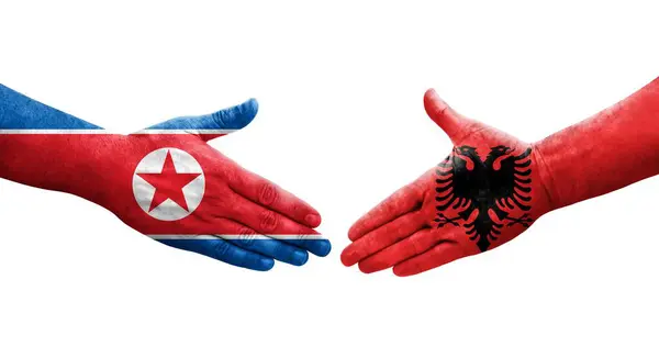 アルバニアと北朝鮮の間の握手手に描かれた旗 孤立した透明画像 — ストック写真
