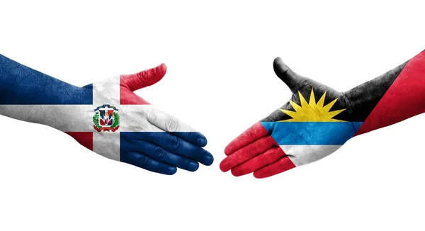 stock image Handshake between Antigua and Barbuda and Dominican Republic flags painted on hands, isolated transparent image.