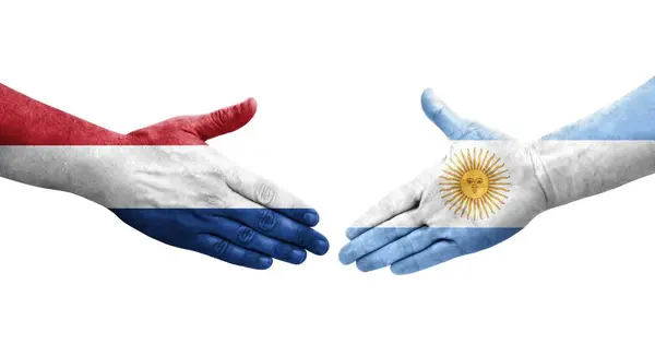 Stock image Handshake between Argentina and Netherlands flags painted on hands, isolated transparent image.